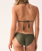 Woman wearing a green bikini top and bottom on a plain background