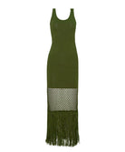 A green long dress with fringe against a white wall. 