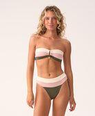 Woman wearing a two-piece swimsuit with pink and green stripes on a white background