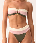 Woman wearing a colorful bandeau bikini on a plain background