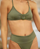 A close up view of a woman wearing a green bikini. 