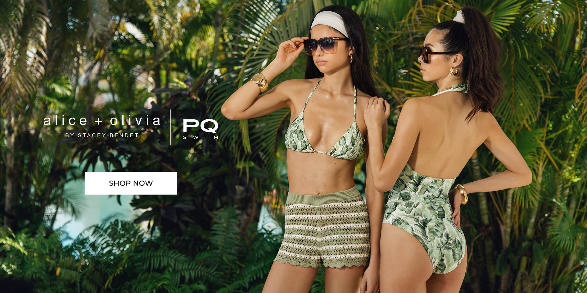Two women in swimwear standing in a tropical setting with 'alice + olivia' branding.