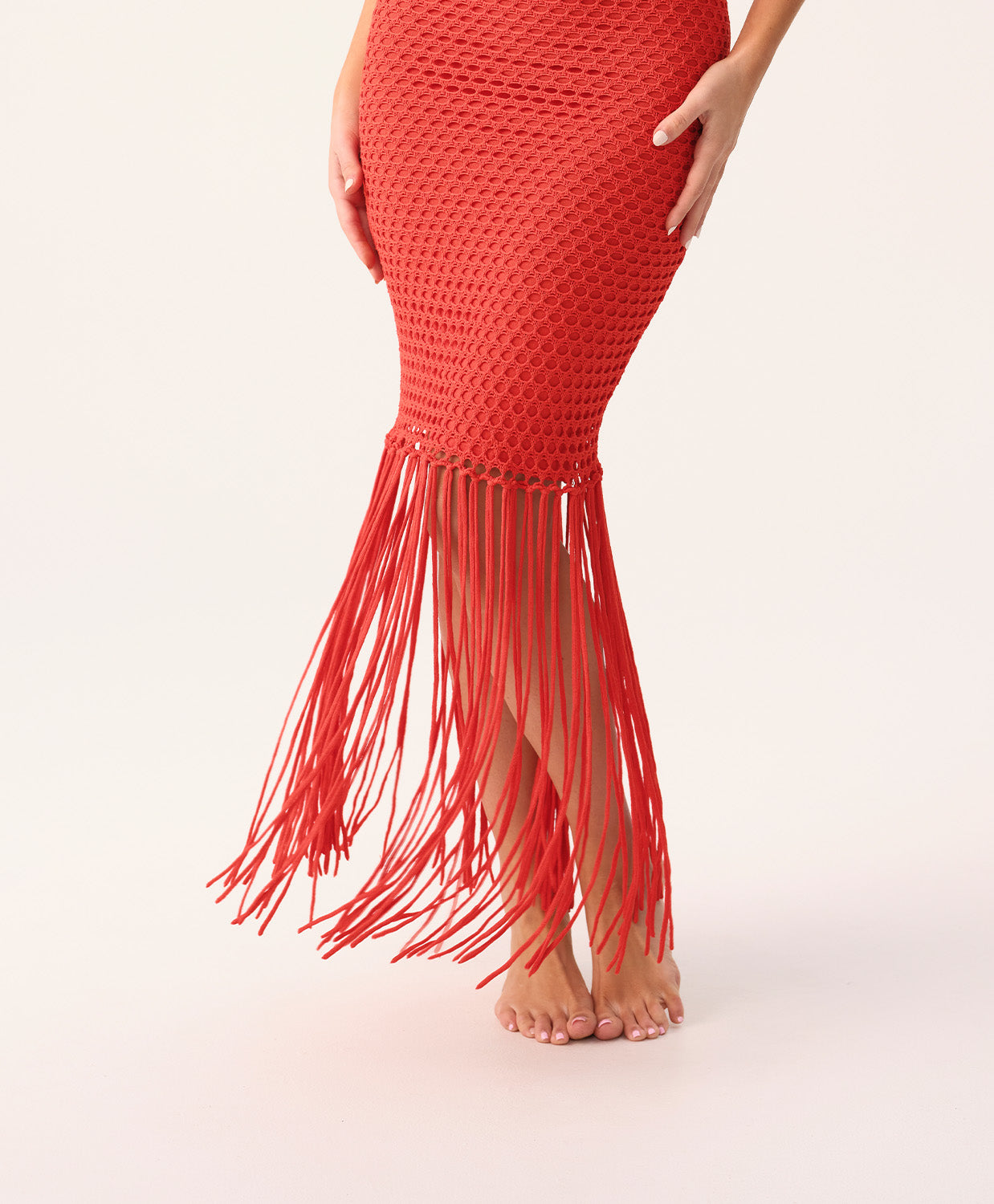 Woman wearing a red fringe dress on a white background