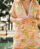 Woman wearing a floral outfit with a pool and outdoor setting in the background
