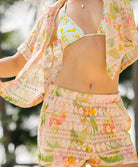 Woman wearing a floral two-piece swimsuit with a matching cover-up.
