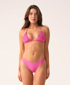 Woman wearing a pink bikini against a white background