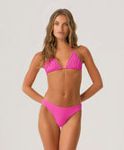 Woman wearing a pink bikini against a plain background