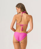Woman wearing a pink bikini on a light gray background