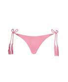Pink bikini bottoms with a tie side closure against a white wall.