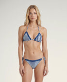 Woman wearing a blue and white striped bikini on a plain background