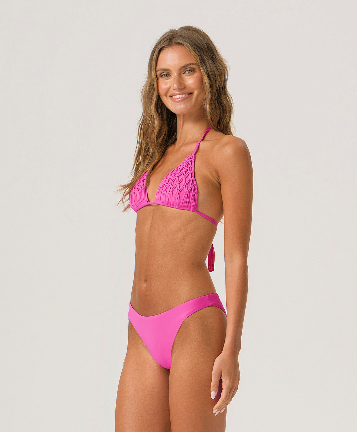 Woman wearing a pink bikini against a light gray background