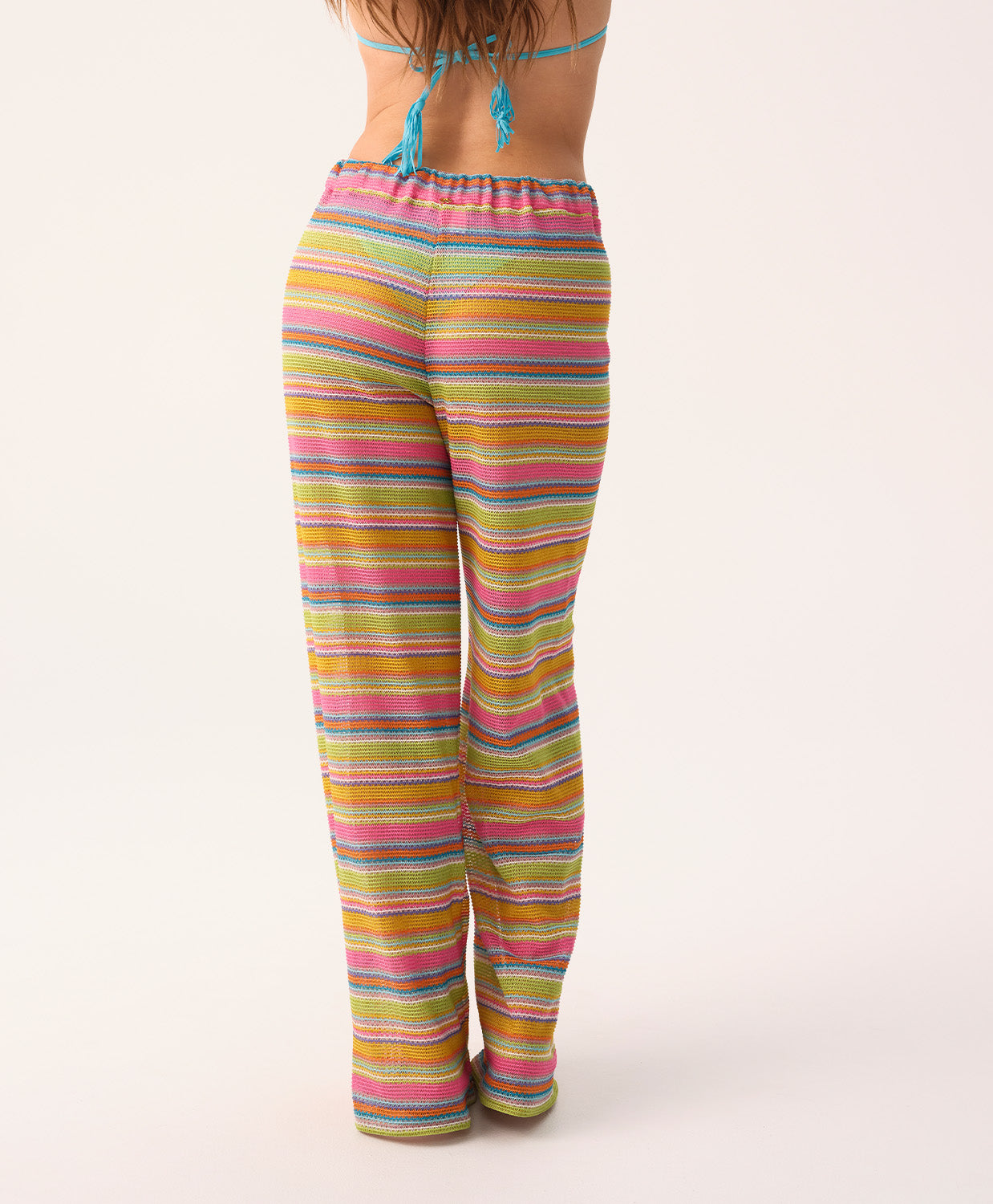 Woman wearing colorful striped pants on a white background