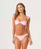 Woman wearing a pink lace bikini set on a white background