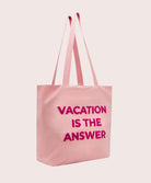 Pink tote bag with 'Vacation is the Answer' text on a light pink background