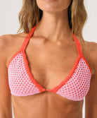 Woman wearing a red and pink bikini top with a plain background