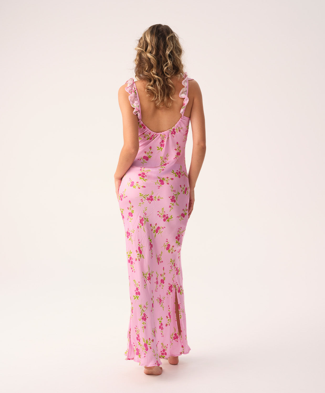 Woman wearing a pink floral long dress on a white background