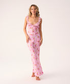 Woman wearing a pink floral long dress on a white background