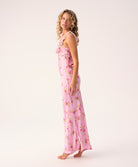 Woman wearing a pink floral long dress on a white background