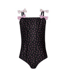 Black swimsuit with pink floral patterns and bow straps on a white background