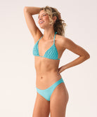 Woman wearing a turquoise bikini against a white background