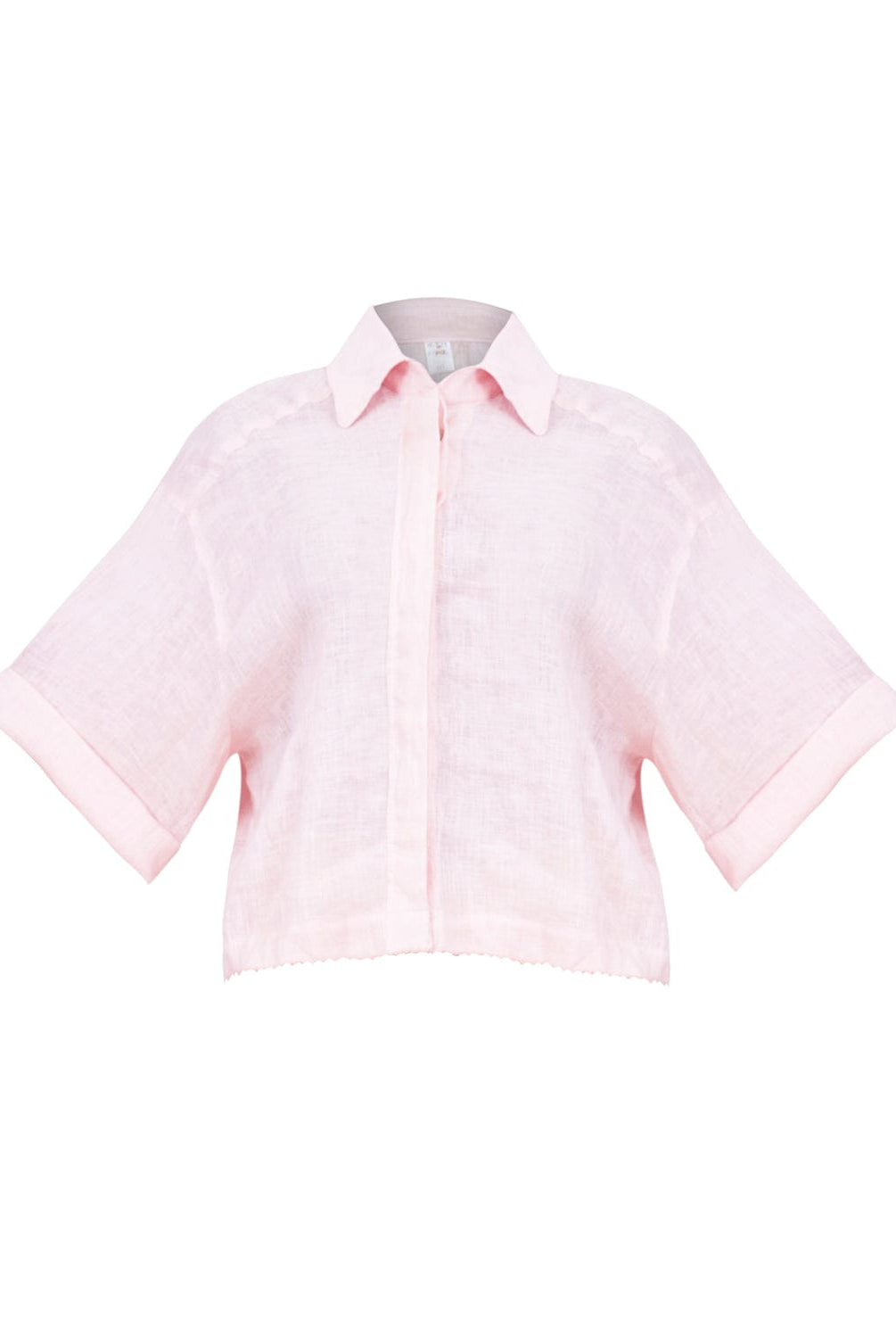 A pink linen button coverup shirt. Featured against a white wall background.