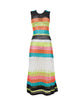 A multi-colored striped full length dress. Featured against a white wall background.