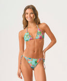 Woman wearing a colorful floral bikini on a white background