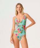 Woman wearing a floral one-piece swimsuit on a white background