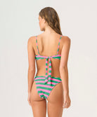 Woman wearing a green and pink striped bikini on a white background