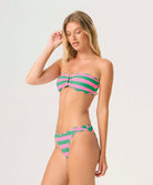 Woman wearing a pink and green striped bikini against a white background