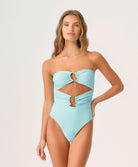 Woman wearing a light blue strapless swimsuit with cut-out design on a white background