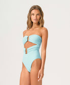 Woman wearing a light blue strapless swimsuit with cut-out design on a white background