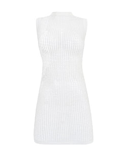 A white dress with crochet details against a white wall. 