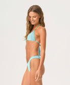 Woman wearing a light blue bikini against a white background