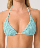 Light blue bikini top on a person against a neutral background
