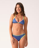 Woman wearing a blue bikini with colorful crochet trim on a white background