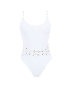 A white one piece with gold beads against a white wall. 