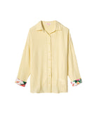 Yellow striped shirt with floral cuffs on a white background