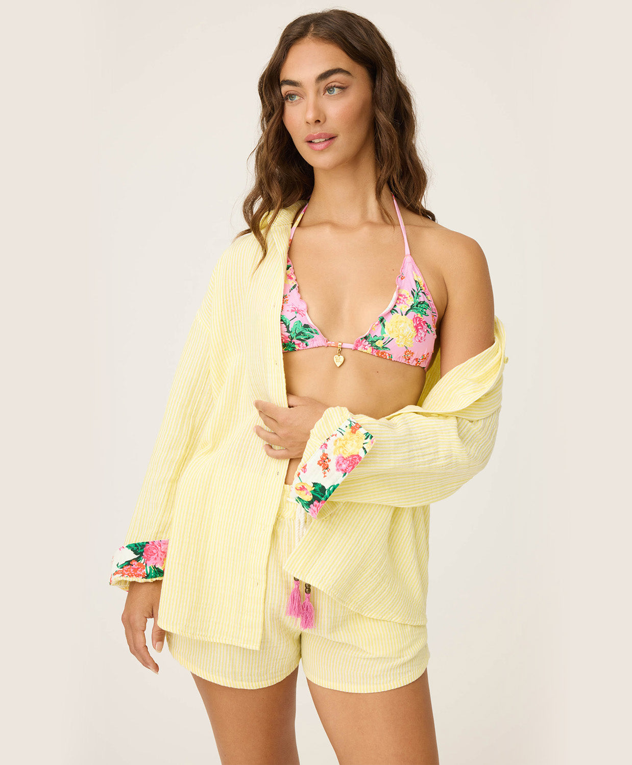 Yellow Gauze Long Sleeve with subtle yellow and white stripes, rolled-up sleeves revealing tropical floral print, button-up front and crisp collar.