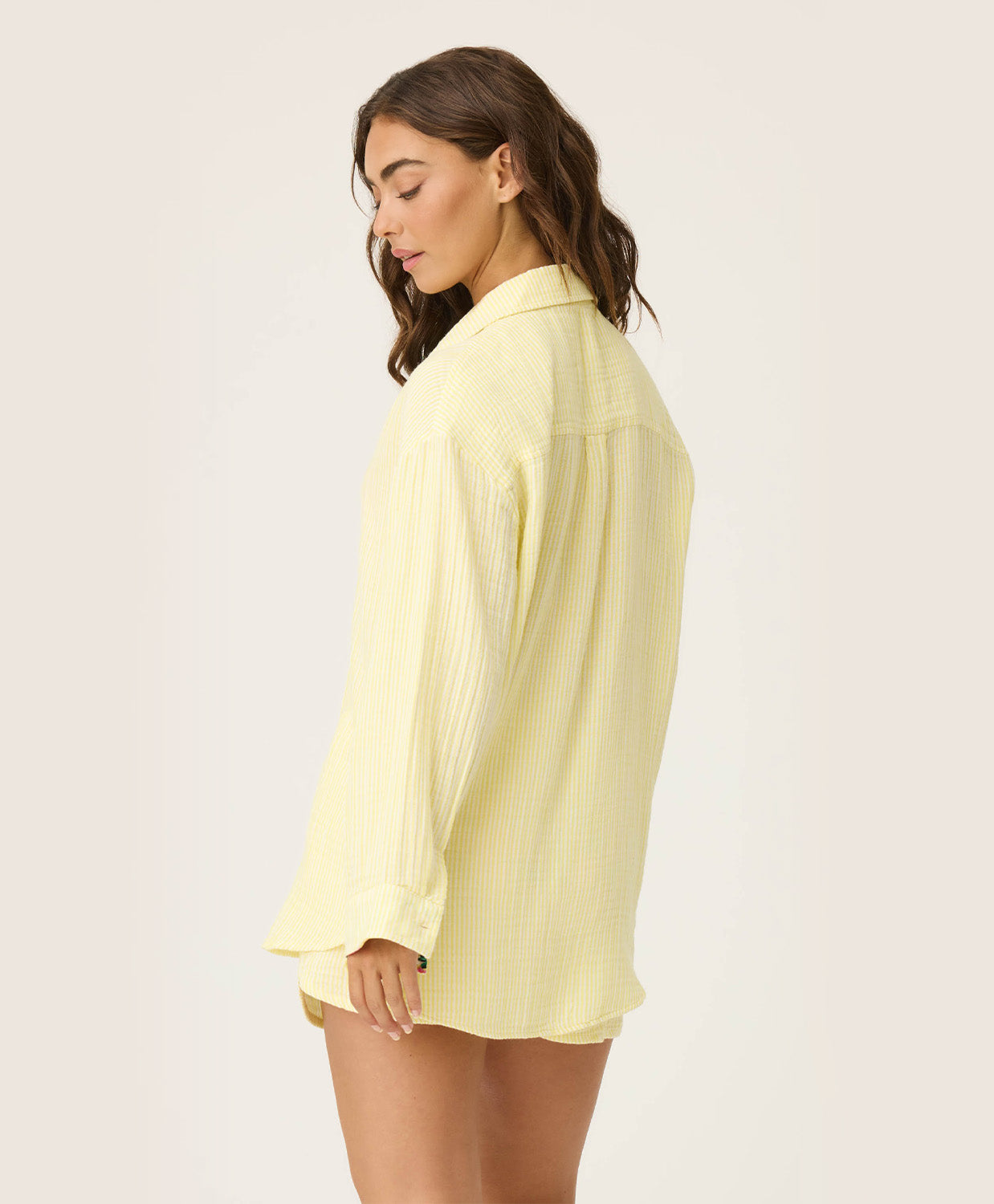 Yellow Gauze Long Sleeve with subtle yellow and white stripes, rolled-up sleeves revealing tropical floral print, button-up front and crisp collar.