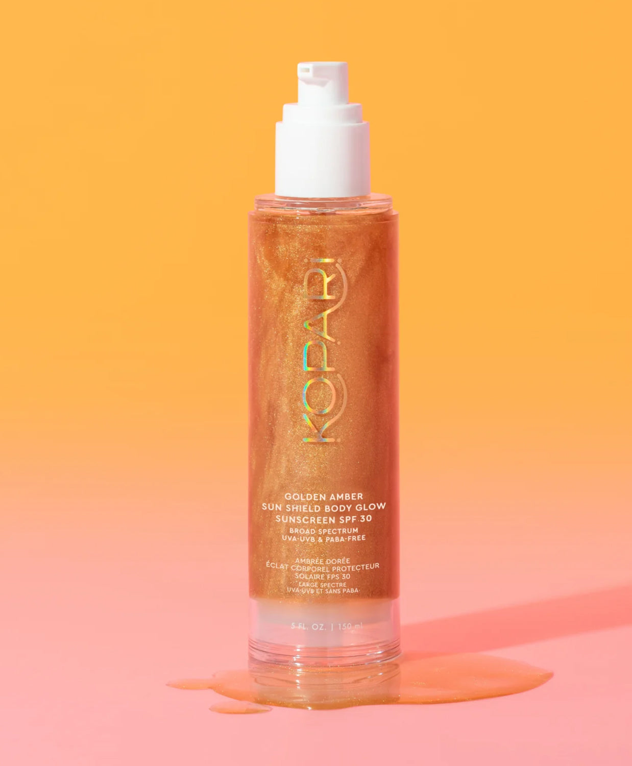 A tube of body glow sunscreen against an orange and pink wall.