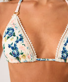 Triangular bikini top with floral pattern and lace trim on a person.