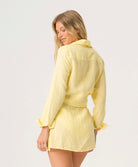 Buttercup Lily Cover Up in pastel yellow linen with classic collar, tailored sleeves, and adjustable side tie.