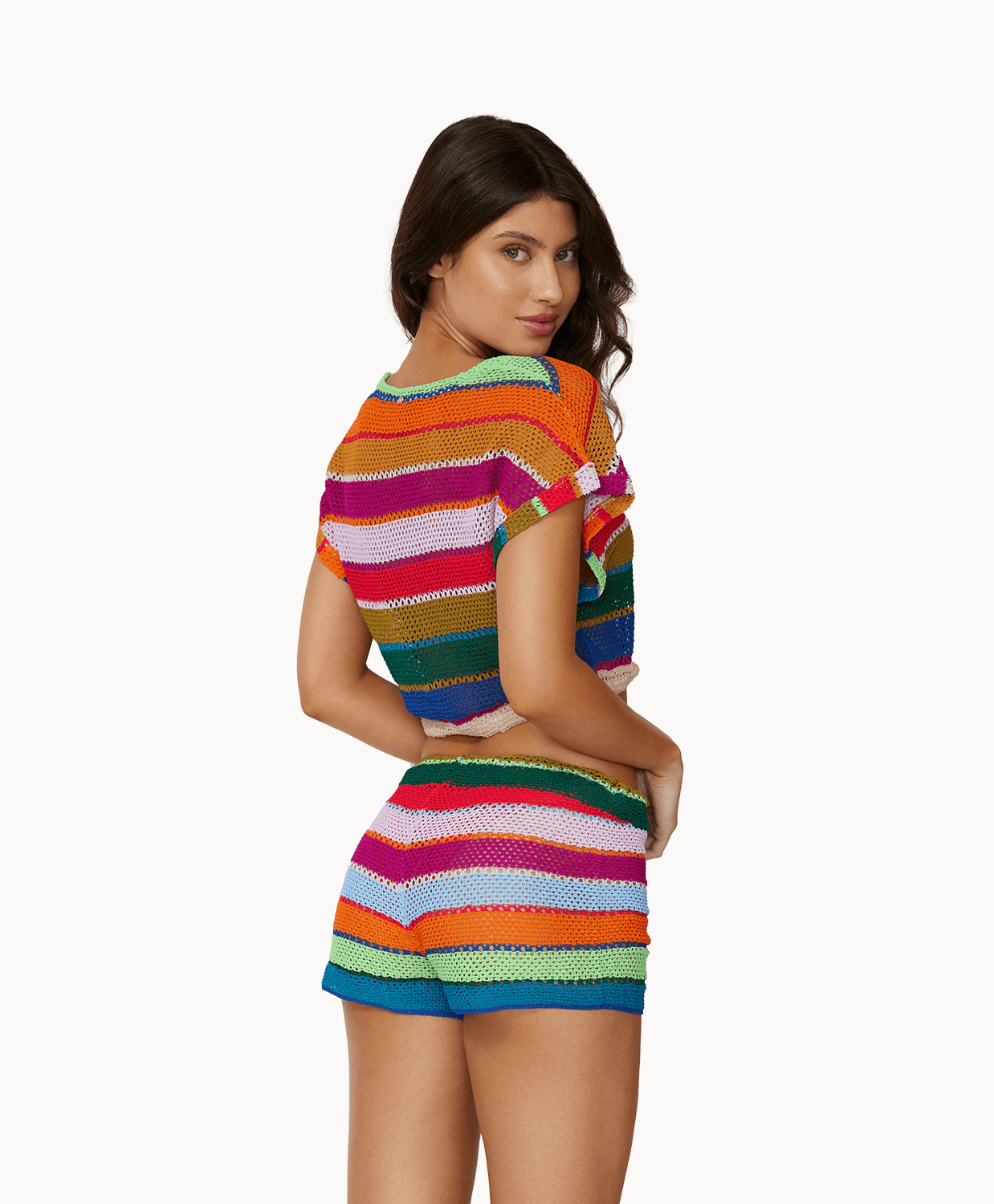 Back view of woman wearing matching colorful, knit top and shorts in front of a white background. 