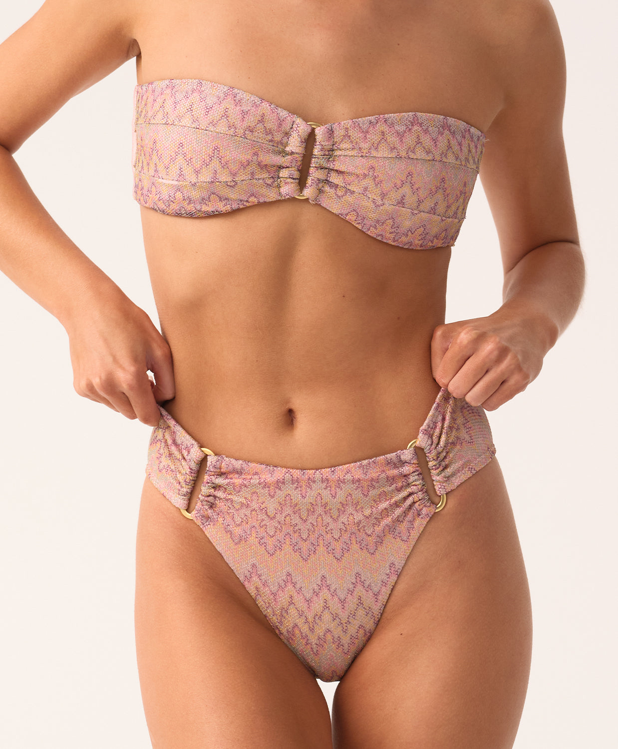 Woman wearing a pink and purple patterned bikini against a white background
