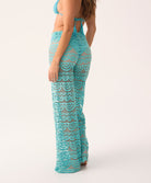 Rear view of a woman wearing blue high waisted pant and a matching bikini top, on a white background.