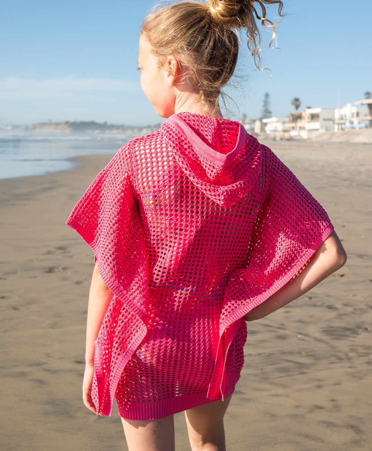 Kids Hot Pink Reagan Poncho with cozy hood and drawstrings, perfect for breezy beach days and post-swim comfort.