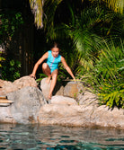 Kids Turquoise Zip One Piece swimsuit with high neck, bright turquoise color, orange collar, and pink front zipper.