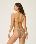 Woman wearing a leopard print bikini against a white background