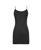 A woman wearing a short luxe layers midnight slip dress standing against a white wall.